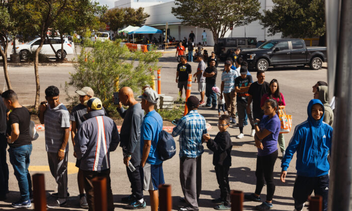 망명을 신청한 불법 이민(체류)자 들이 미 텍사스 주 샌안토니오에 있는 카톨릭 자선단체에서 제공하는 식룦품을 받기 위해 기다리고있다. 2022.09.19 | Jordan Vonderhaar/Getty Images