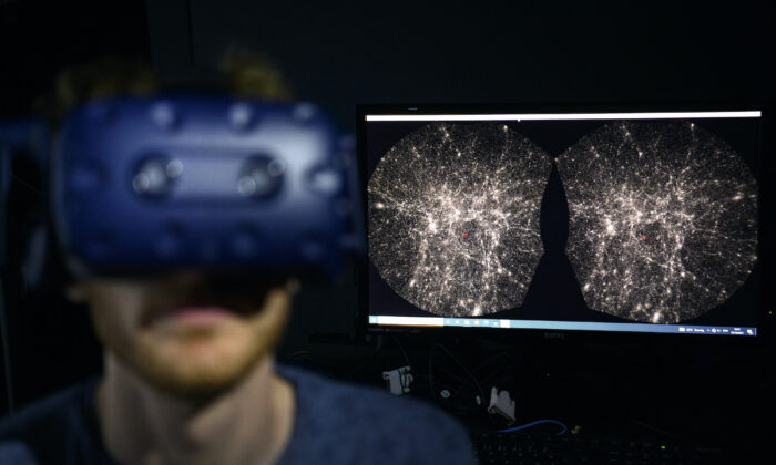 스위스 로잔에 있는 로잔연방공과대학(EPFL)의 힌 연구소에서 소프트웨어 엔지니어가 가상 현실 헬멧을 쓰고 우주 3D 지도를 탐색하고 있다. 2021.10.12일 | Laurent Gillieron/Keystone, AP=연합뉴스