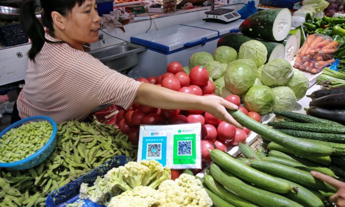 2018.09.10 중국 장쑤성 난퉁시의 한 시장에서 판매자가 손님을 위해 야채를 포장하고 있다 | STR/AFP via Getty Images