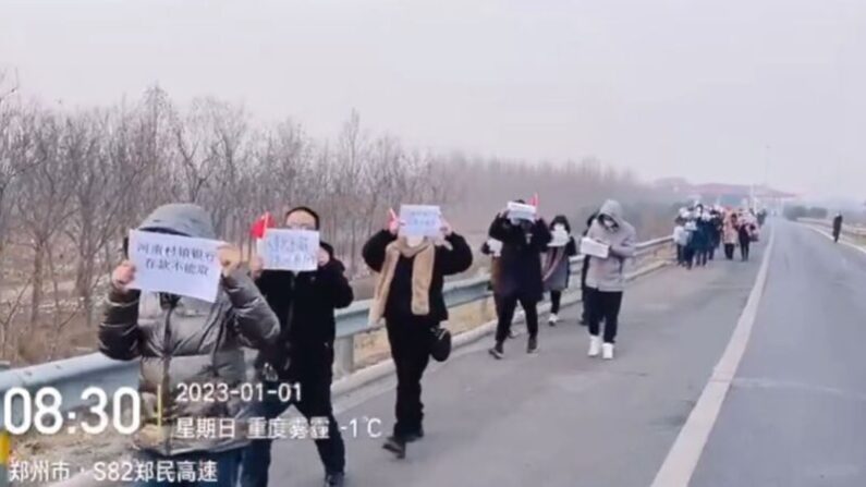 새해 첫날, 허난 촌진은행(村鎮銀行) 예금자들이 백지를 들고 “내 예금 돌려달라”고 외치며 고속도로를 따라 행진하고 있다. | 영상 캡처