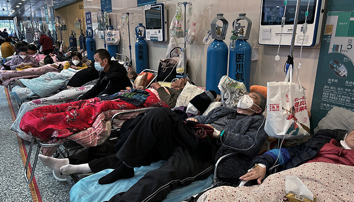 2023년 1월 12일 중국 상하이의 한 병원에 환자들이 응급실 구역 복도에 기대 쉬고 있다. | Kevin Frayer/Getty Images