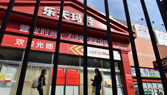 2017년 9월, 사람들이 중국 베징에 있는 폐쇄된 롯데 매장 앞을 지나가고 있다. 
롯데 그룹은 당시 한국 정부의 사드(THAAD·고고도미사일방어체계) 배치로 인한 중국 당국의 압력에 “일부 중국 매각할 것”이라고 밝혔다. | GREG BAKER/AFP via Getty Images=연합뉴스