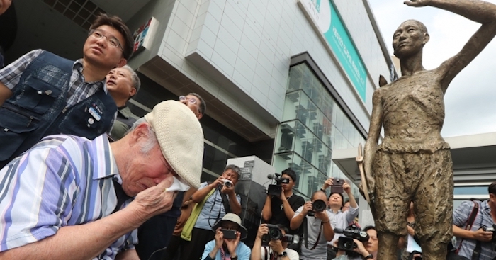 징용 피해자가 서울 용산에서 울음을 떠뜨리고 있는 가운데 취재진이 이를 카메라로 촬영하고 있다. 2022.2.12 | 연합뉴스

