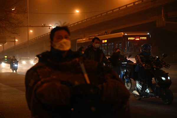 지난 10일 베이징에 황사가 들이닥친 가운데 마스크를 쓴 행인들이 중심업무지구를 지나고 있다. | by Jade Gao/AFP/연합뉴스