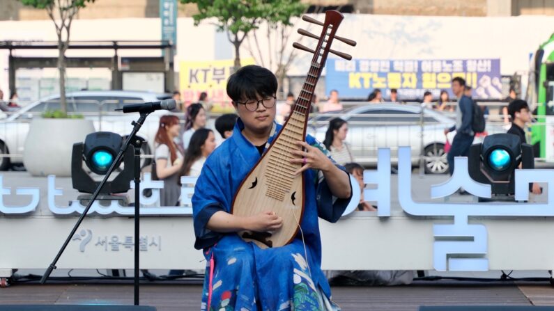 6월 23일 광화문광장 놀이마당에서 열린 '문화가 흐르는 예술마당' 무대에서 비파 연주자 마롱이 연주하고 있다. | 박재현/에포크타임스