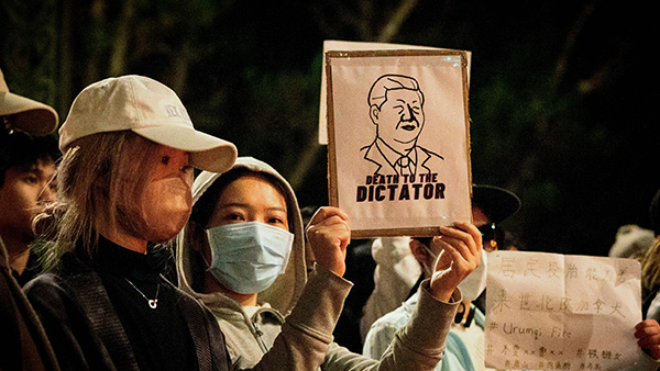 지난해 11월, 미국 캘리포니아대에서 중국 청년들이 시진핑 중국 공산당 총서기의 '제로 코로나' 방역 정책에 항의하는 모습. 사신 속 여성은 '시진핑 퇴진'을 요구하는 내용의 피켓을 들고 있다. (기사 내용과 무관한 사진). | JOSH EDELSON/AFP via Getty Images=연합