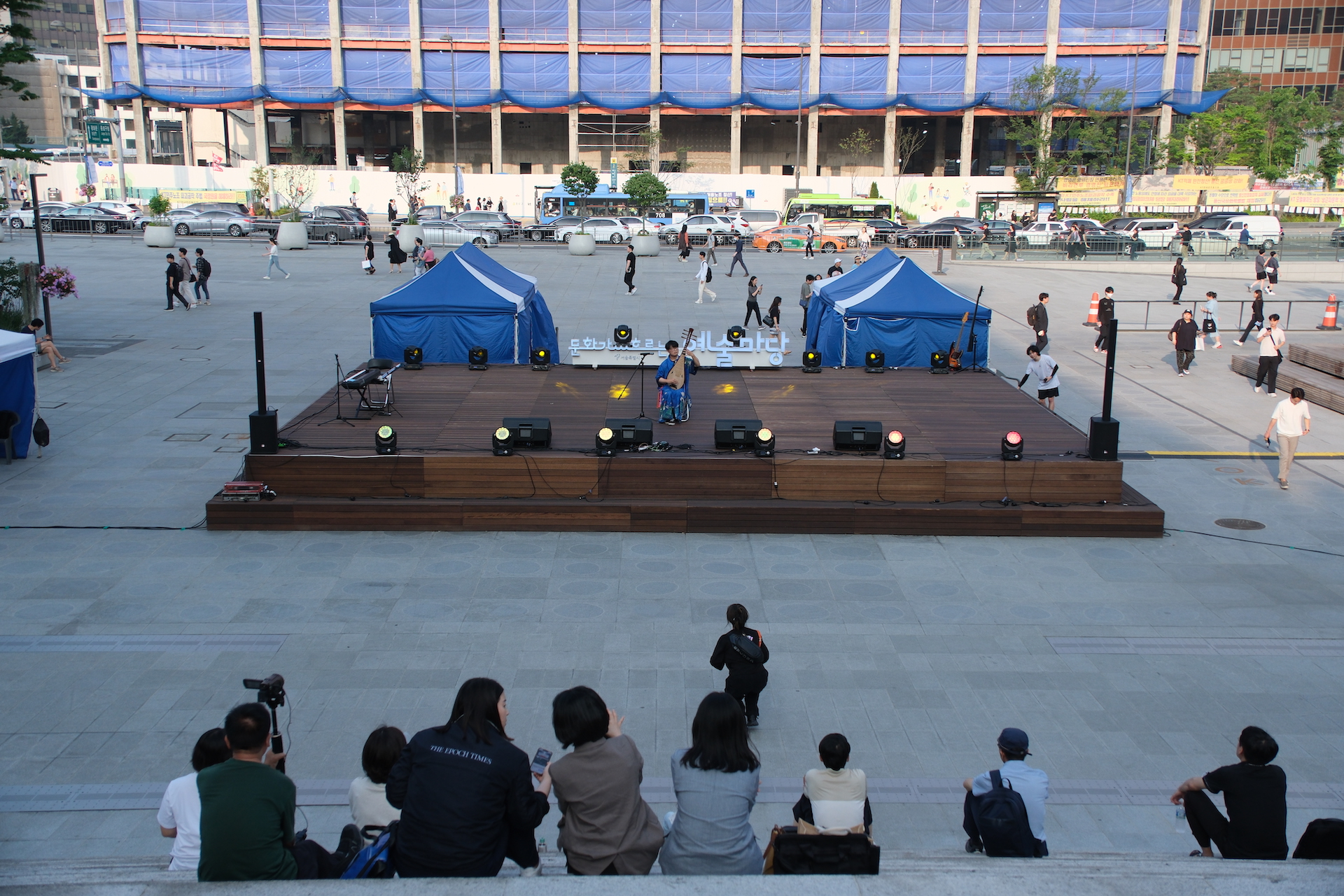 2023년 6월 서울 광화문광장 놀이마당에서 열린 행사 ‘문화가 흐르는 예술마당’에서 비파 연주자 마롱의 공연을 시민들이 보고 있다. | 박재현/에포크타임스