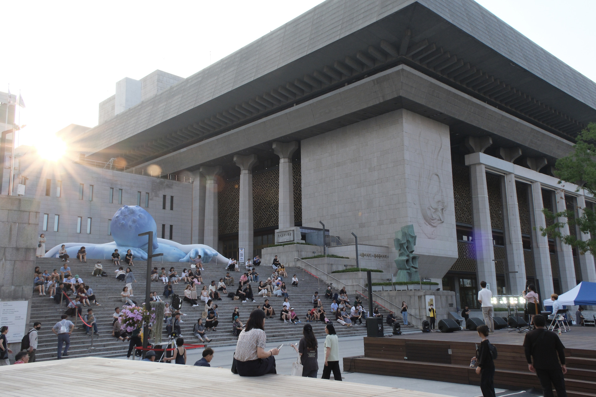 시민들이 세종문화회관 야외 계단에 앉아 '문화가 흐르는 예술마당' 공연을 감상하고 있다 | 박재현/에포크타임스