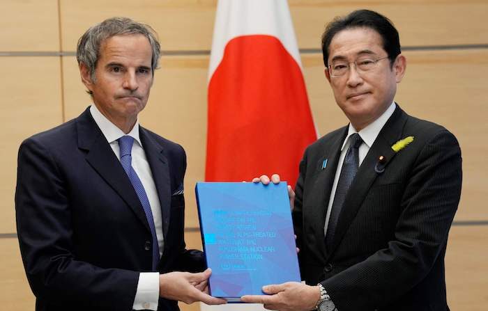 4일 일본 도쿄 총리관저를 방문한 라파엘 그로시 국제원자력기구(IAEA) 사무총장이 기시다 후미오 일본 총리에게 일본 후쿠시마 제1원전 오염 처리수 방류 계획에 관한 평가가 담긴 최종보고서를 건네고 있다. | Eugene Hoshiko/POOL/AFP/연합