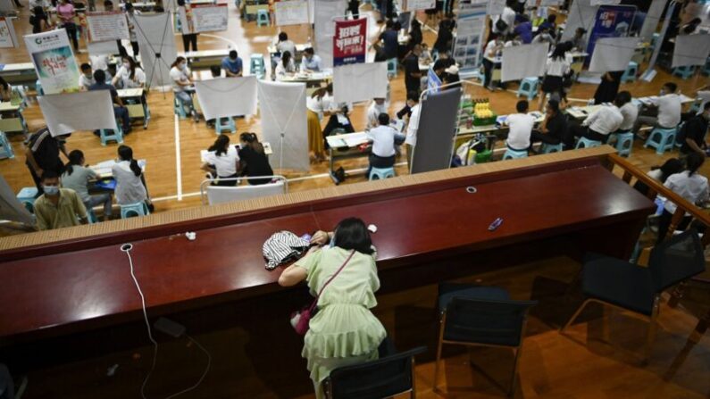 자료사진: 중국 정저우의 한 취업박람회장에서 한 구직자가 책상에 엎드린 채 휴식하고 있다. 2020.7.25 | WANG ZHAO/AFP via Getty Images/연합
