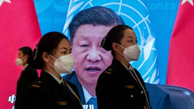 2022년 10월 20일 중국 베이징에서 열린 제20차 중국 공산당 전국대표대회 프레스센터에서 보안요원들이 방문객을 확인하려 대기 중인 가운데, 시진핑 중국 공산당 총서기의 모습이 뒤쪽의 대형 스크린에 표시된다. | Kevin Frayer/Getty Images