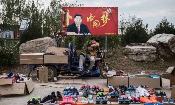 중국 허베이성에서 한 중국 상인이 시진핑 중국 국가주석의 표지판 앞에서 신발을 판매하고 있다.｜Kevin Frayer/Getty Images/연합뉴스