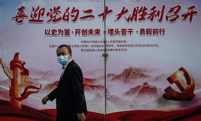 지난 2022년 9월 중국 베이징 한 거리에서 행인이 제20차 중국공산당 전국대표대회 선전 포스터 앞을 지나가고 있다.｜Jade Gao/AFP via Getty Images/연합뉴스