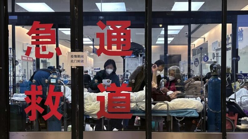 중국 상하이의 한 병원에서 응급실  병상 부족으로 한 입구를 폐쇄해 임시 응급실로 사용하고 있다. 창문 너머로 환자와 간병인들이 보인다. 2023.1.14 | Kevin Frayer/Getty Images
