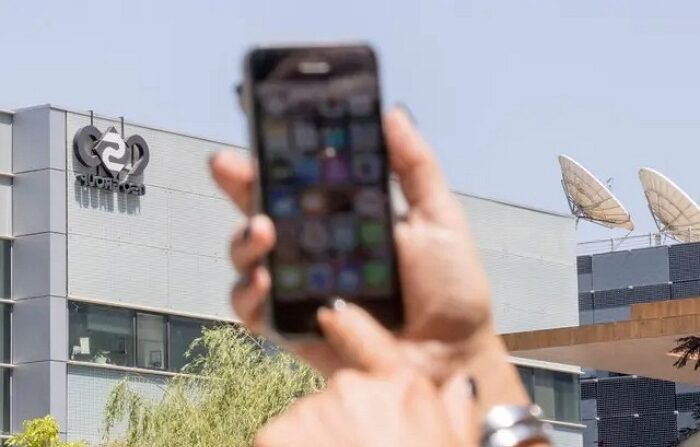 지난 2016년 한 이스라엘 시민이 이스라엘의 민간 정보기술 기업 NSO그룹 건물 앞에서 아이폰을 사용하고 있다.｜Jack Guez/AFP via Getty Images/연합뉴스