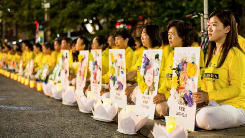 2019년 7월 13일, 캐나다 토론토 중국 영사관 앞에서 파룬궁 수련자들이 중국에서 박해로 사망한 동료 수련자들의 사진을 들고 촛불집회에 참여하고 있다. | Handout