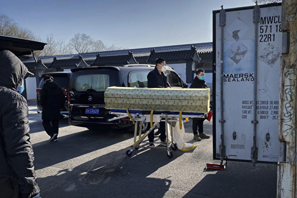 2022년 12월 18일 중국 베이징에서 코로나19 사망자를 처리하는 화장터 중 한 곳인 둥자오 화장터에 시신을 담은 관이 운구돼 보관용 컨테이너로 옮겨지고 있다. | Getty Images