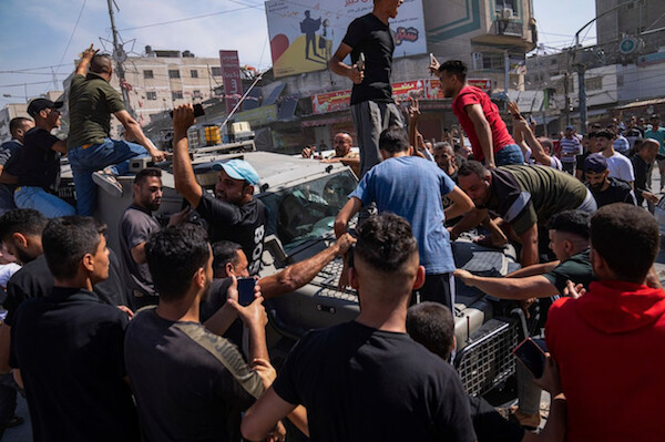 7일(현지시간) 팔레스타인 무장세력이 이스라엘에서 팔레스타인 가자지구로 운전해온 이스라엘 군용 차량 주변에 팔레스타인인들이 모여있다. 2023.10.7 | AP/연합뉴스