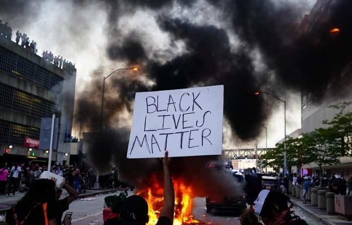 지난 2020년 5월 29일(현지 시간) 미국 애틀랜타에서 조지 플로이드 사망에 항의하는 시위가 열린 가운데 한 남성이 BLM 팻말을 들고 있다.｜Elijah Nouvelage/Getty Images/연합뉴스