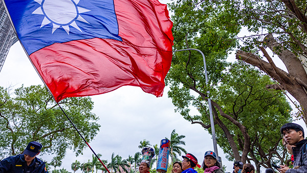 지난 24일 대만 타이베이에서 한 국민당 지지자가 중앙선거위원회 청사 밖에서 대만 국기를 흔들고 있다. 이날은 대만 대선 후보 등록일이었다. | Annabelle Chih/Getty Images