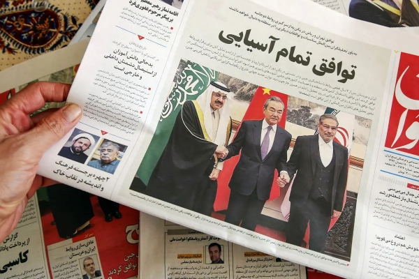 3 월 11 일 테헤란에서 한 남성이 이란과 사우디아라비아 간의 관계 정상화에 대한 보도가 실린 신문을 들고 있다. | Atta Kenare/AFP via Getty Images