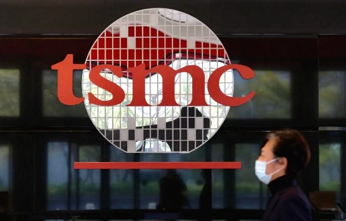 2021년 1월 29일, 대만에 있는 세계 최대 반도체 제조업체인 TSMC 본사의 회사 로고 앞을 한 남성이 지나가고 있다. | Sam Yeh/AFP via Getty Images