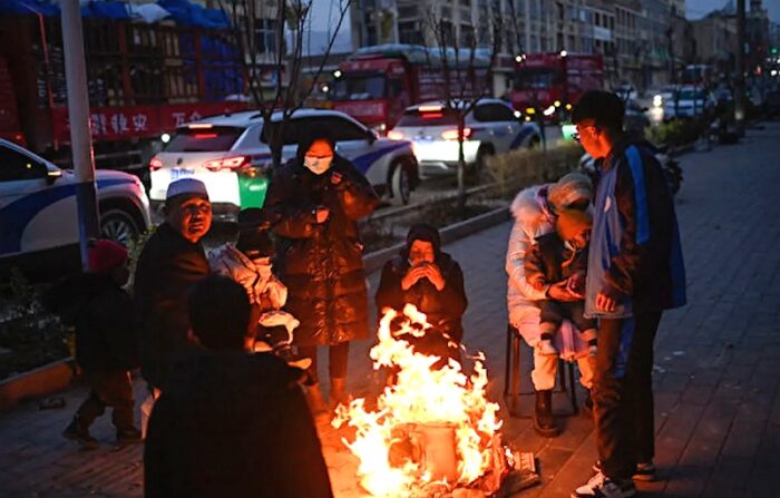 2023년 12월 19일, 중국 간쑤성에서 지진이 발생한 뒤 사람들이 추위를 피하기 위해 모닥불 앞에 모여 있다. | Pedro Pardo/AFP