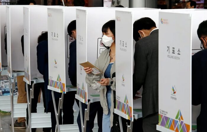 2020년 4월 10일, 한국 서울의 한 투표소에서 한 여성이 제21대 국회의원 선거 사전투표를 한 뒤 기표소를 나서고 있다. | Heo Ran/Reuters