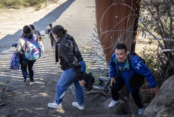 불법 이민자들이 미국 국경 장벽 틈새를 통과해 캘리포니아로 들어서고 있다. 이들은 다른 곳으로 이동하는 대신 국경 순찰대가 나타나기를 기다렸다가 순순히 이송되는 것을 선택한다. 2023.12.7 | John Fredricks/The Epoch Times
