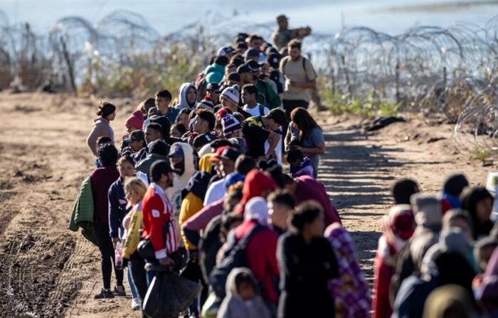 2023년 12월 18일, 미국 텍사스주 이글패스로 국경을 건너온 불법 이민자들이 미 국경순찰대 현장처리센터 주변에서 줄을 서 있다. | John Moore/Getty Images