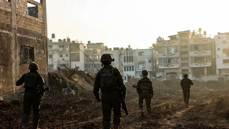 이스라엘과 팔레스타인 무장정파 하마스 간의 전투가 계속되는 가운데 가자지구 북부에서 군사 작전 중 이스라엘 군인들이 파손된 건물들 사이로 걸어가고 있다. 2023.12.19 | GIL COHEN-MAGEN/AFP via Getty Images/연합뉴스