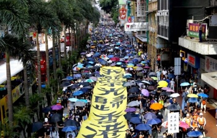 2019년 10월 5일, 홍콩에서 열린 민주화 시위에서 시위대가 '홍콩에 영광이 다시 오길'이라고 적힌 현수막 옆을 지나고 있다. | AP Photo/Vincent Thian/연합뉴스