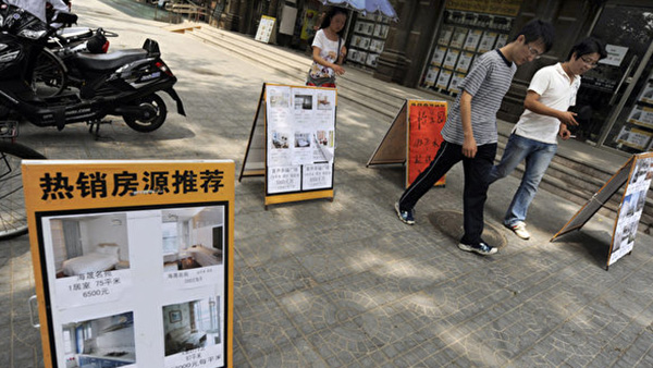 베이징의 한 부동산 중개사무소 앞을 지나가는 행인들. | PETER PARKS/AFP/Getty Images/연합 