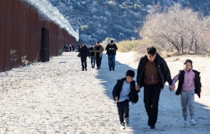 2023년 12월 6일, 미국 국경 장벽을 따라 걷고 있는 이민자들의 모습 | John Fredricks/The Epoch Times