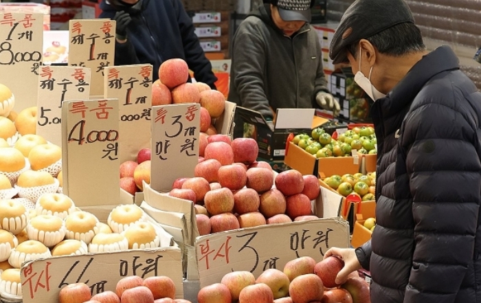 지난 6일 오후 서울 동대문구 청량리청과물시장에서 한 시민이 사과를 둘러보고 있다.｜연합뉴스