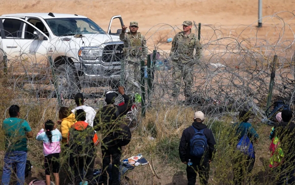 2024년 2월 29일, 미국 텍사스주 방위군이 철조망을 넘어오는 불법 이민자들을 막고 있다. | Herika Martinez/AFP via Getty Images/연합뉴스