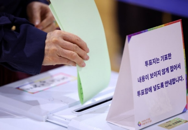 22대 총선일인 4월 10일 서울 여의동주민센터에 마련된 여의동제2투표소를 찾은 한 유권자가 투표함에 용지를 넣고 있다. | 연합뉴스