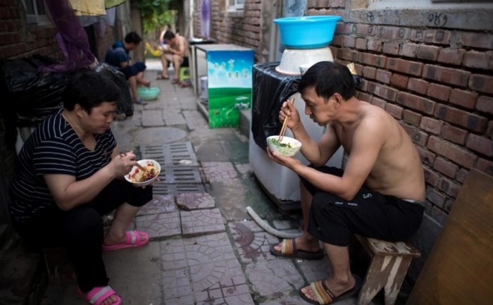2017년 8월 17일, 중국 베이징 외곽의 한 마을 거리에서 주민들이 식사를 하고 있다. | Nicolas Asfouri/AFP/Getty Images/연합뉴스