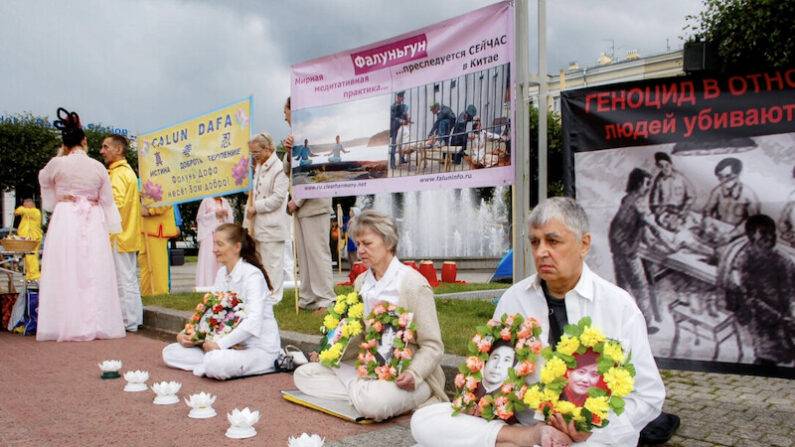 러시아 상트페테르부르크 핀란스키역 앞 광장에서 파룬궁 수련자들이 중국에서 박해받다 숨진 수련생들을 추모하고 있다. 2013.7.20 | 이리나 오시로바/에포크타임스