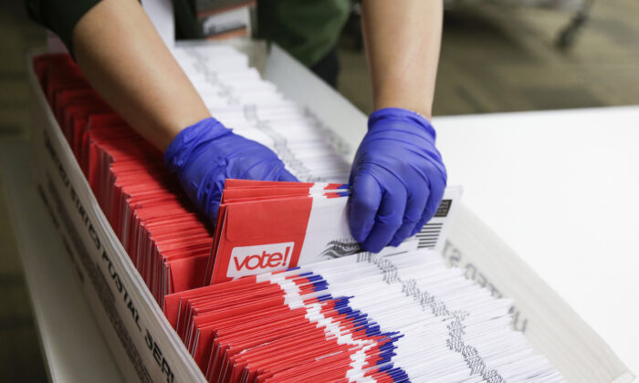 지난 3월 10일 워싱턴주 킹카운티에서 대통령 예비선거용 우편투표용지를 작업자들이 분류하고 있다. | Jason Redmond/AFP by Getty Images
