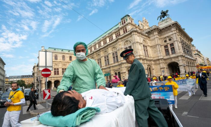 Falun Gong practitioners in Vienna, Austria, stage a demonstration of organ harvesting of imprisoned practitioners in China during a protest against importing of human organs from China to Austria on Oct. 1, 2018. (Joe Klamar/AFP via Getty Images)