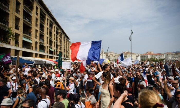 프랑스 남부에 위치한 제2의 도시 마르세이유에서 시위대가 백신 접종 의무화와 백신 여권 도입에 항의하며 자유를 상징하는 프랑스 깃발을 흔들고 있다. | Clement Mahoudeau/AFP via Getty Images/연합
